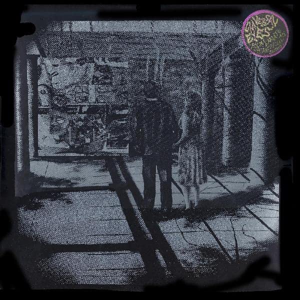 Dark, grainy album cover with a distorted interior scene and pink seal.
