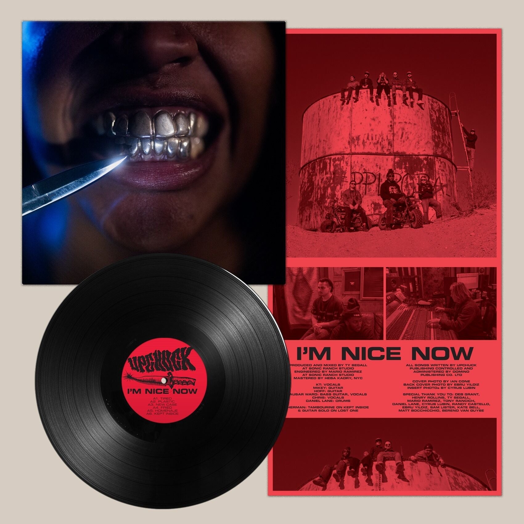 Vinyl record with album art featuring a mouth with grillz and a red landscape.