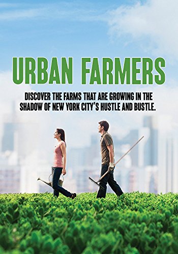 A man and woman walk through a rooftop garden with New York City behind them.