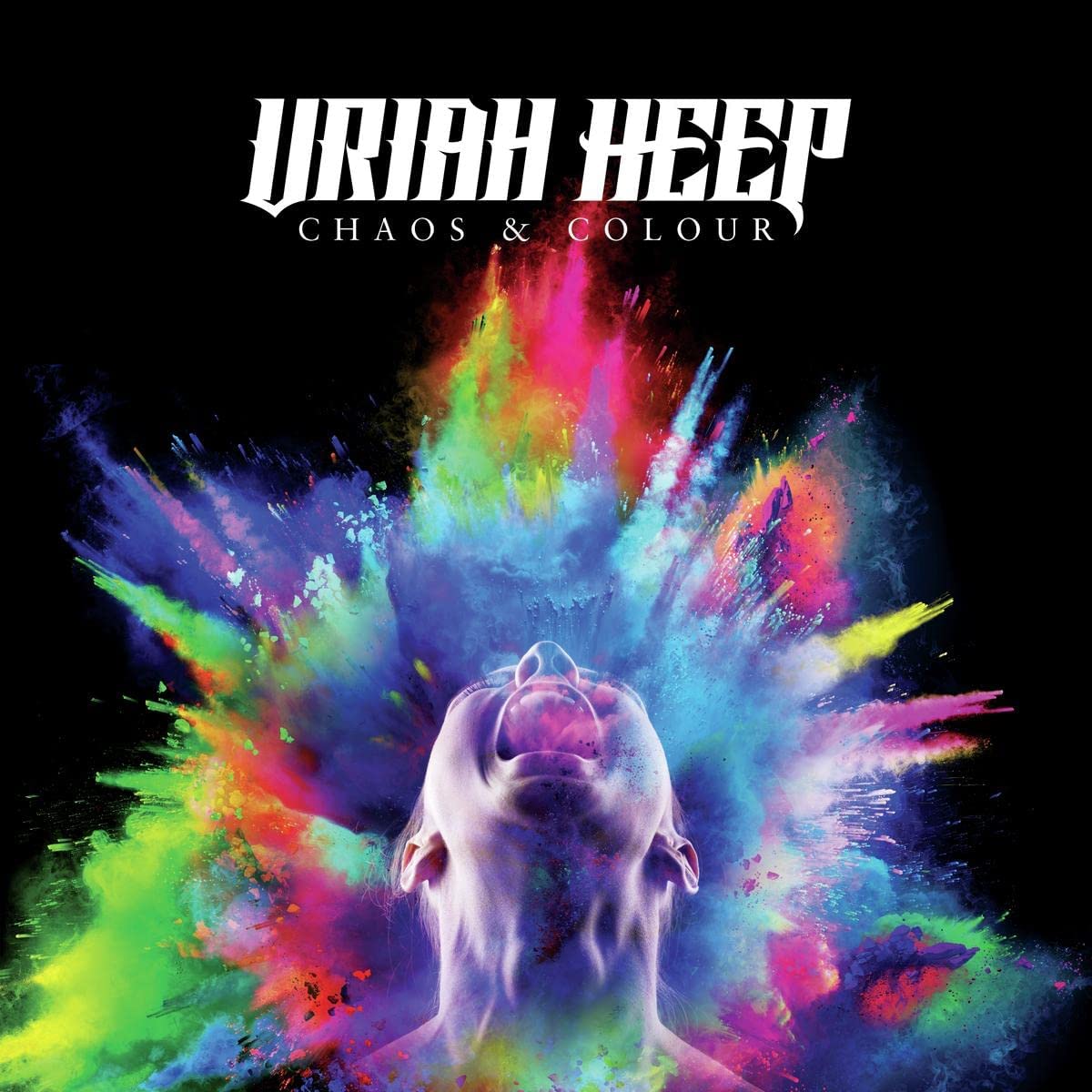 Person looking upward with a colorful explosion of powder against a black background.
