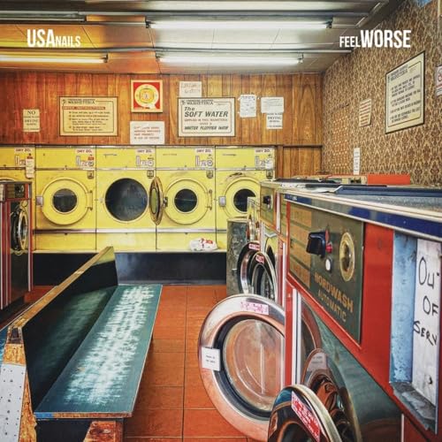 A retro laundromat with yellow and red washing machines and wood-paneled walls.