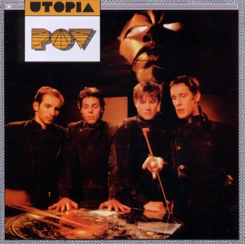 "Album cover with four men standing around a table, with a mask in the background."