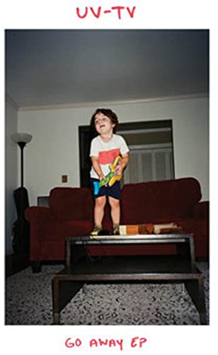 Child standing on furniture, holding a toy, album cover for UV-TV.