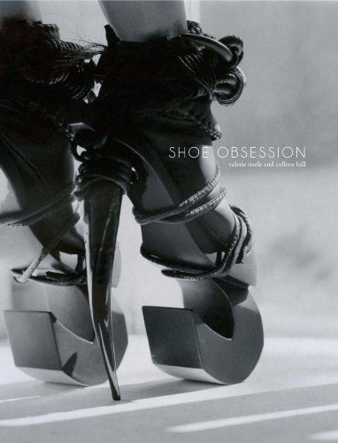 Close-up of black platform shoes with extreme pointed heels, book cover.