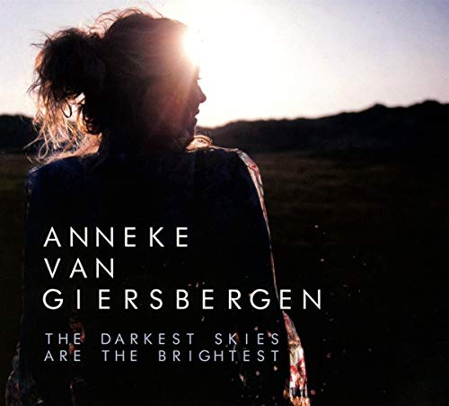 "Album cover featuring a silhouette of a woman against a bright sky with text overlay."