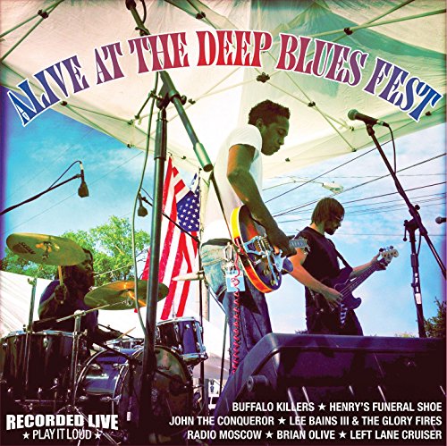Live blues band performing outdoors under a white tent, album cover.