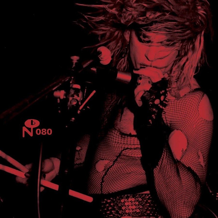 "Red-toned album cover featuring a woman playing drums with flowing hair."