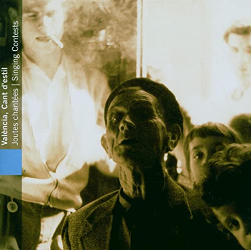 CD cover: close-up of a man with a cap, blurred faces in background.