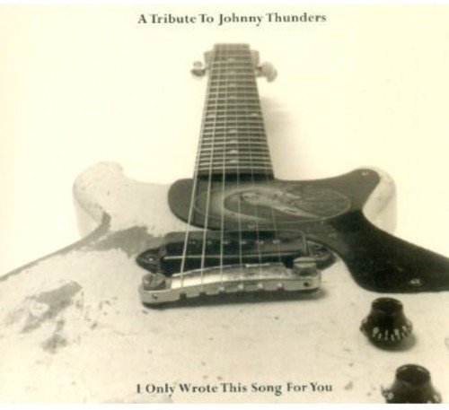 Close-up of a worn electric guitar on a white background with album text.