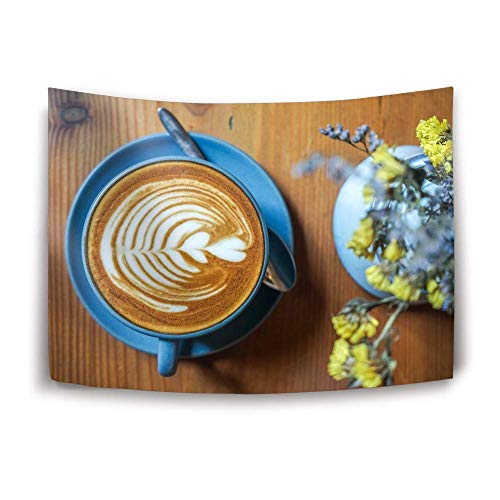 Coffee cup with latte art and a small vase of yellow flowers.