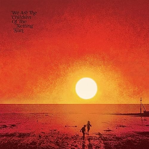 Two children walk on a beach at sunset under a bright orange sky.