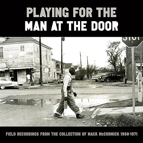 Black and white CD cover with a street scene and walking man.