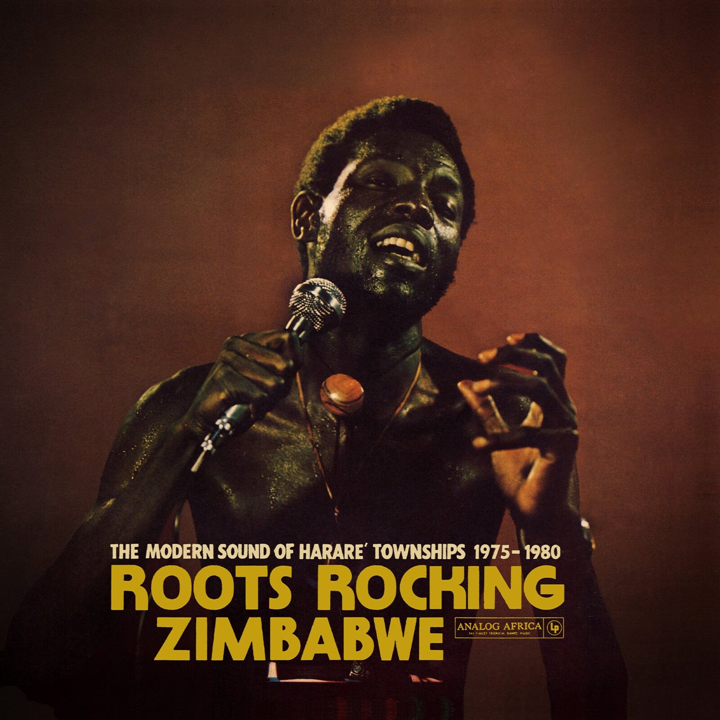 CD cover featuring a singing man in a dark suit, text “Roots Rocking Zimbabwe.”