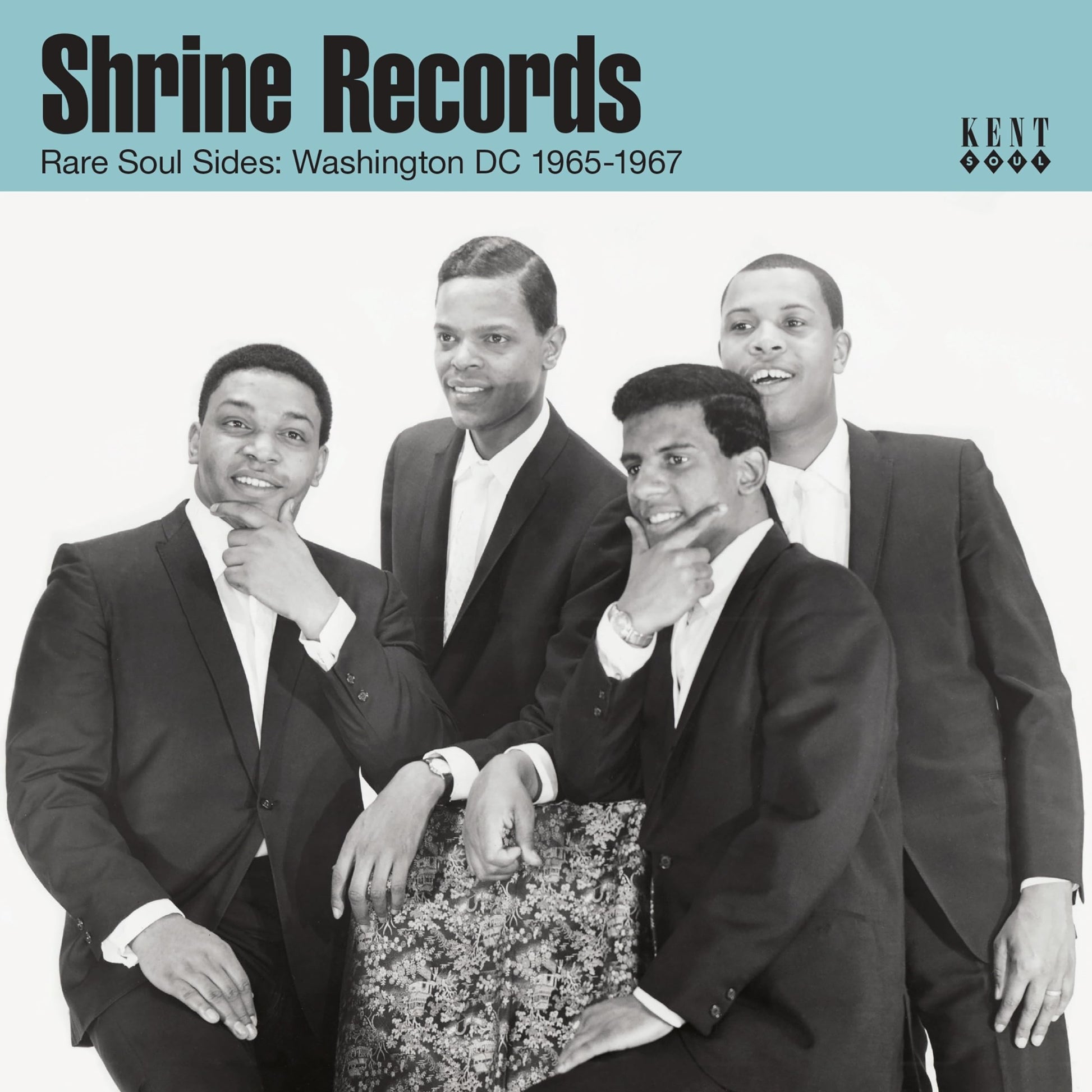 Black and white photo of four men in suits posing for a music album cover.
