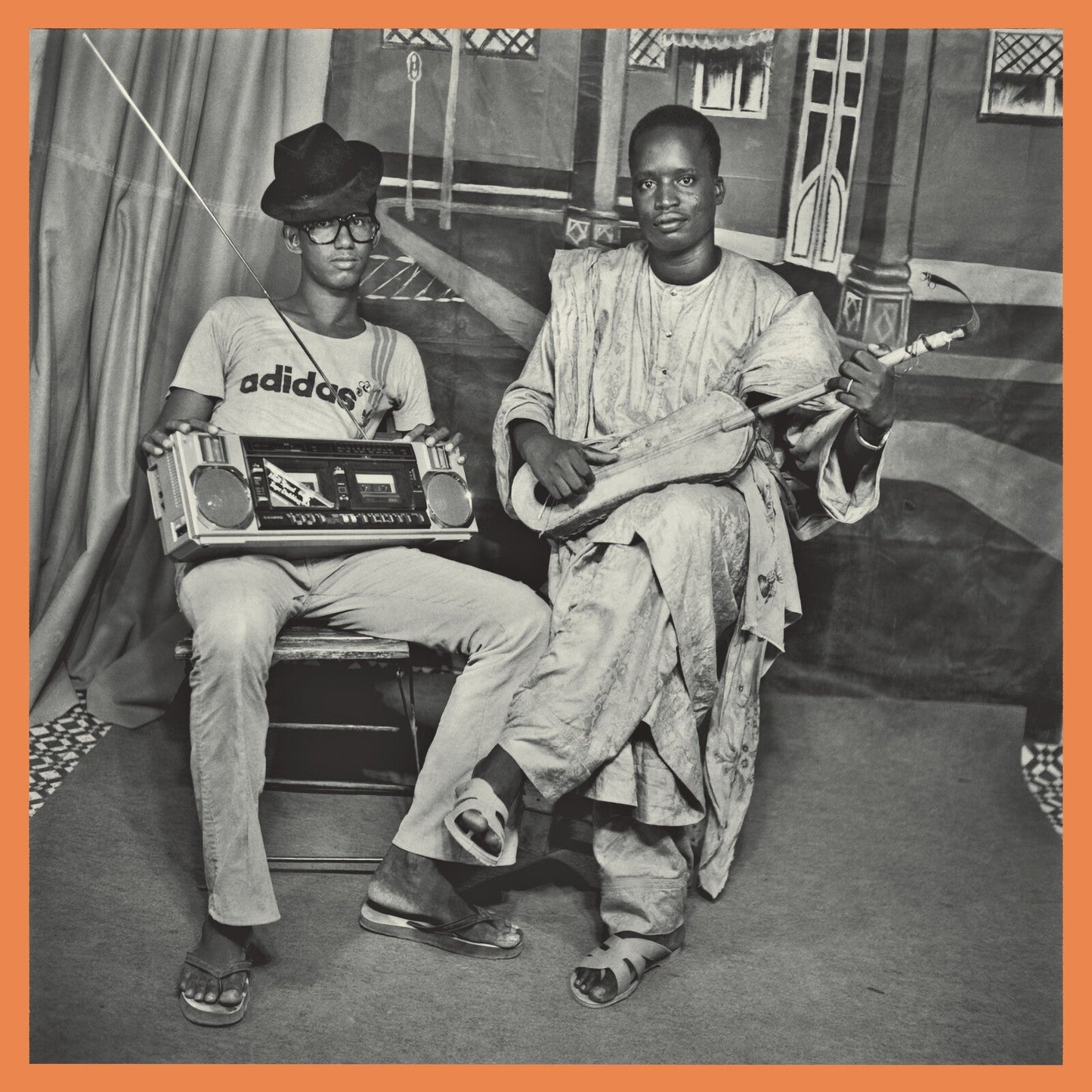 Black and white photo of two men with a boombox and guitar.