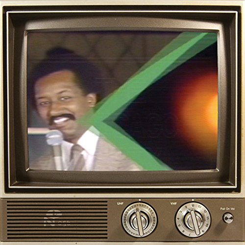 A vintage television screen displaying a man holding a microphone with green graphic overlay.
