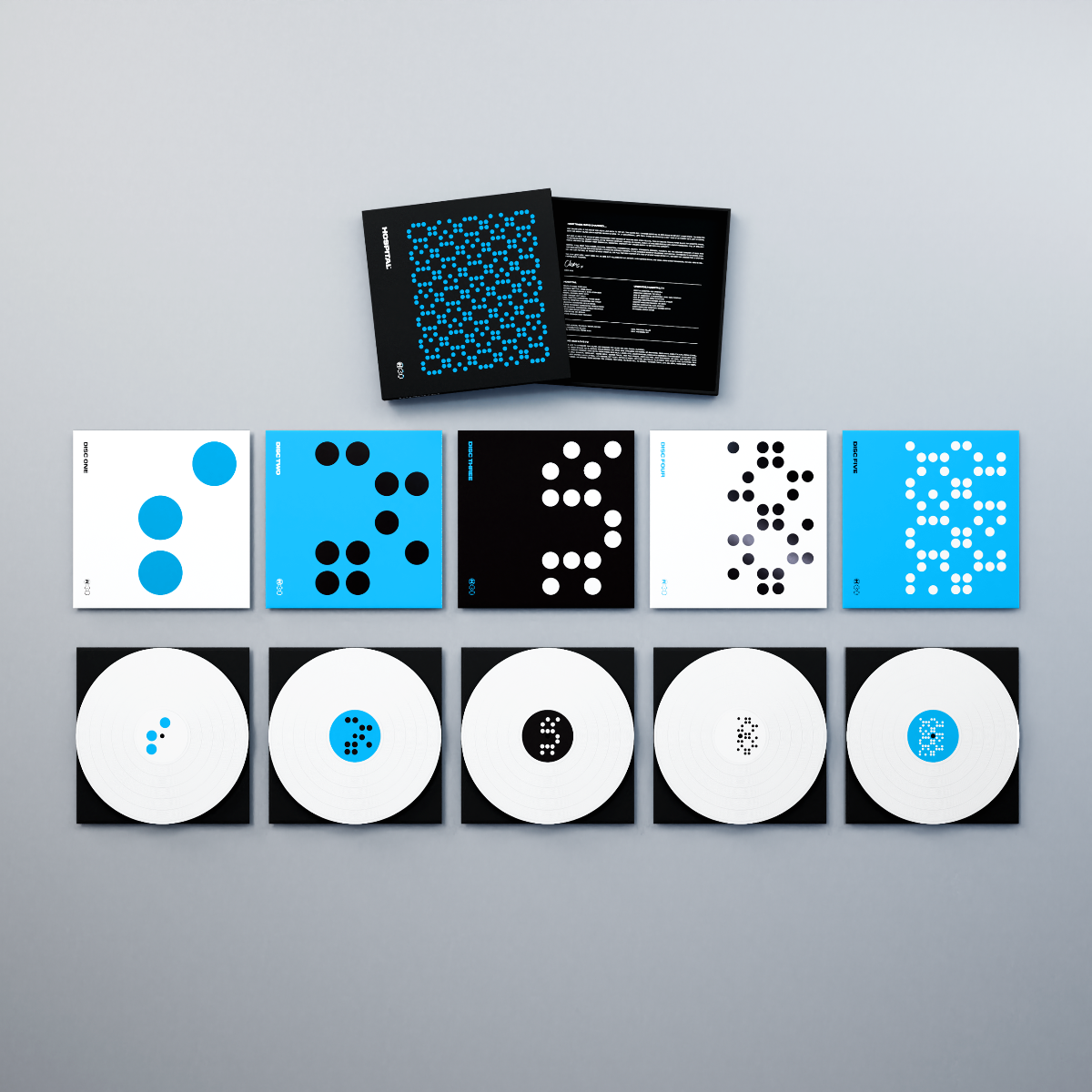 Six white vinyl LPs and two booklets with blue and white dot patterns.