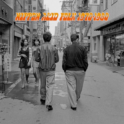 Black and white photo of four people walking down a narrow Japanese city street.