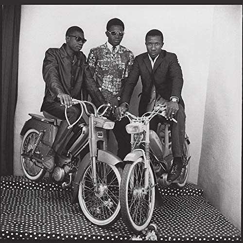 Three men with motorcycles, black and white photograph, vintage style.