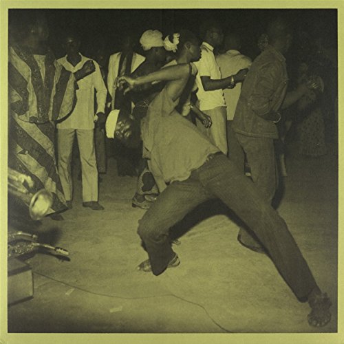 Sepia-toned photograph of a man dancing in a crowd at a social gathering.