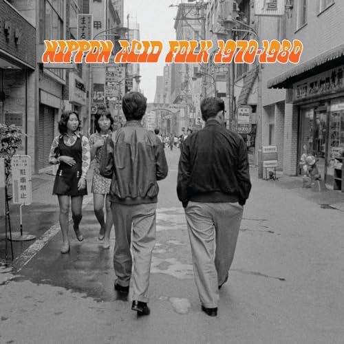 Black and white photo of four people walking down a narrow Japanese city street.