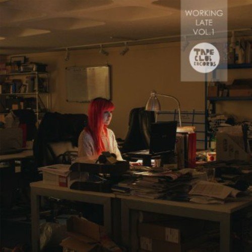CD cover: woman with red hair working at a cluttered desk.