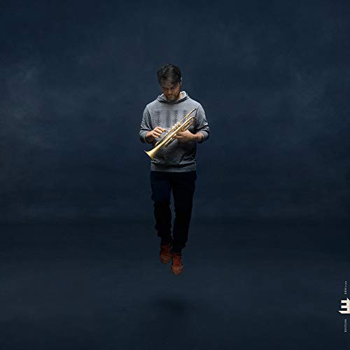 Man holding a trumpet, seemingly floating in a blue, hazy space.