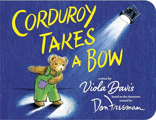 Corduroy the bear stands on stage under a spotlight.