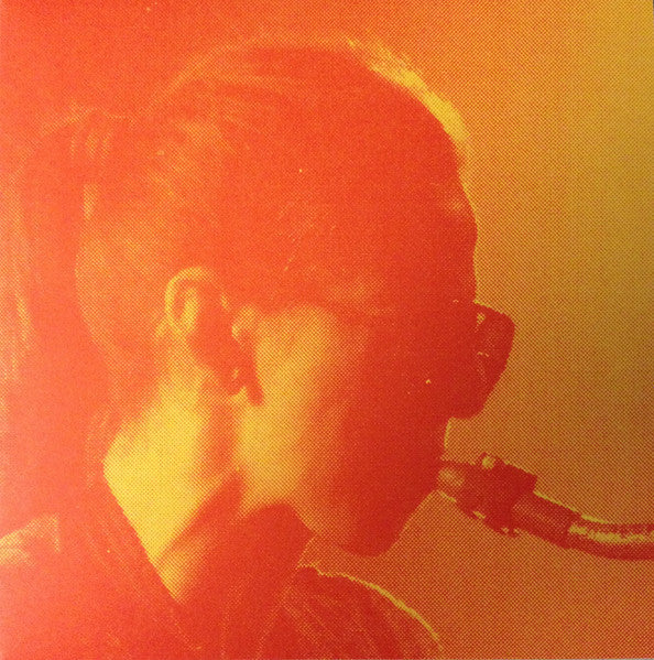 Close-up of a person with sunglasses in a warm, orange-toned image.