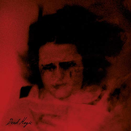 Red-toned portrait of a woman with dark hair, album cover art.