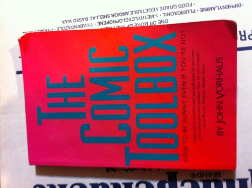 Red book titled The Comic Toolbox by John Vorhaus on newspaper background.