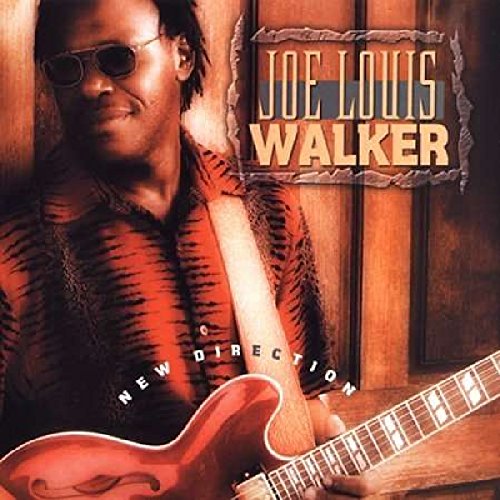Joe Louis Walker wearing sunglasses and a patterned shirt, holding a red electric guitar.