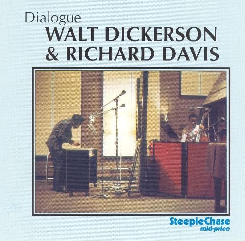 Album cover with two musicians playing instruments on stage, light blue background.