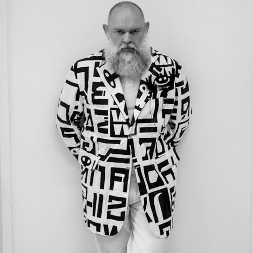 Black and white portrait of a bearded man in a patterned jacket.