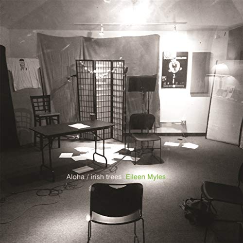 Black and white album cover with chairs, a screen, and scattered papers.