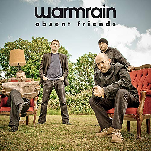 Album cover with four men posing on red armchairs in a grassy outdoor setting.