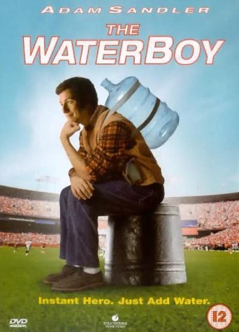 Adam Sandler sits on a bucket in a stadium wearing a water jug backpack.