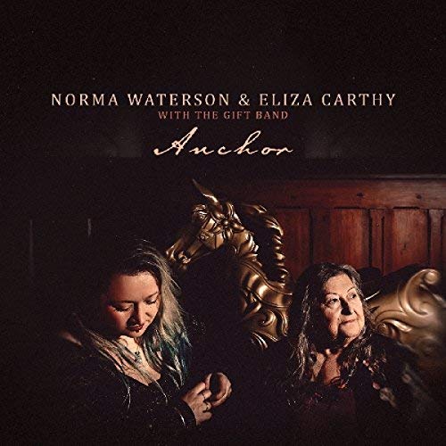 "Album cover featuring two women and a golden horse head sculpture."