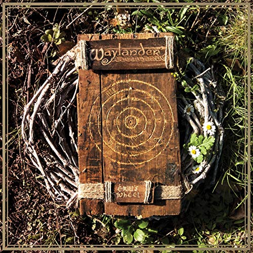 A wooden record sleeve with a spiral design, surrounded by twigs and flowers.
