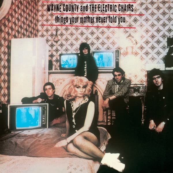 Album cover: band posed with vintage televisions in a patterned room.