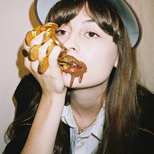 Woman with gold coins and dripping caramel near her mouth.