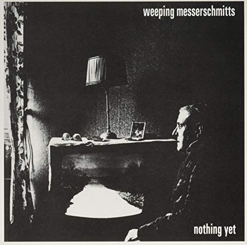 Black and white album cover with a lamp, table, and seated man.