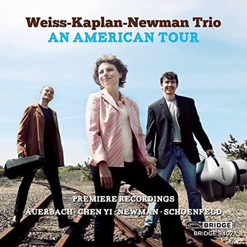Three musicians with instrument cases walking on train tracks under a blue sky.