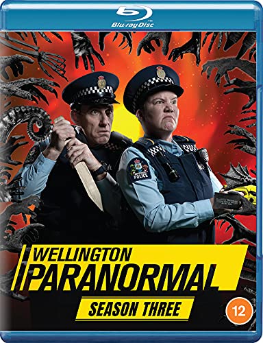 Two police officers stand against an orange background surrounded by reaching monster hands.
