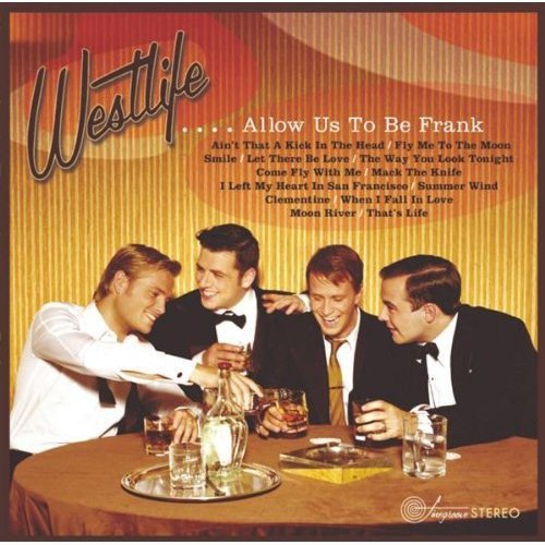 Four men in suits sitting at a table with drinks and a decanter.