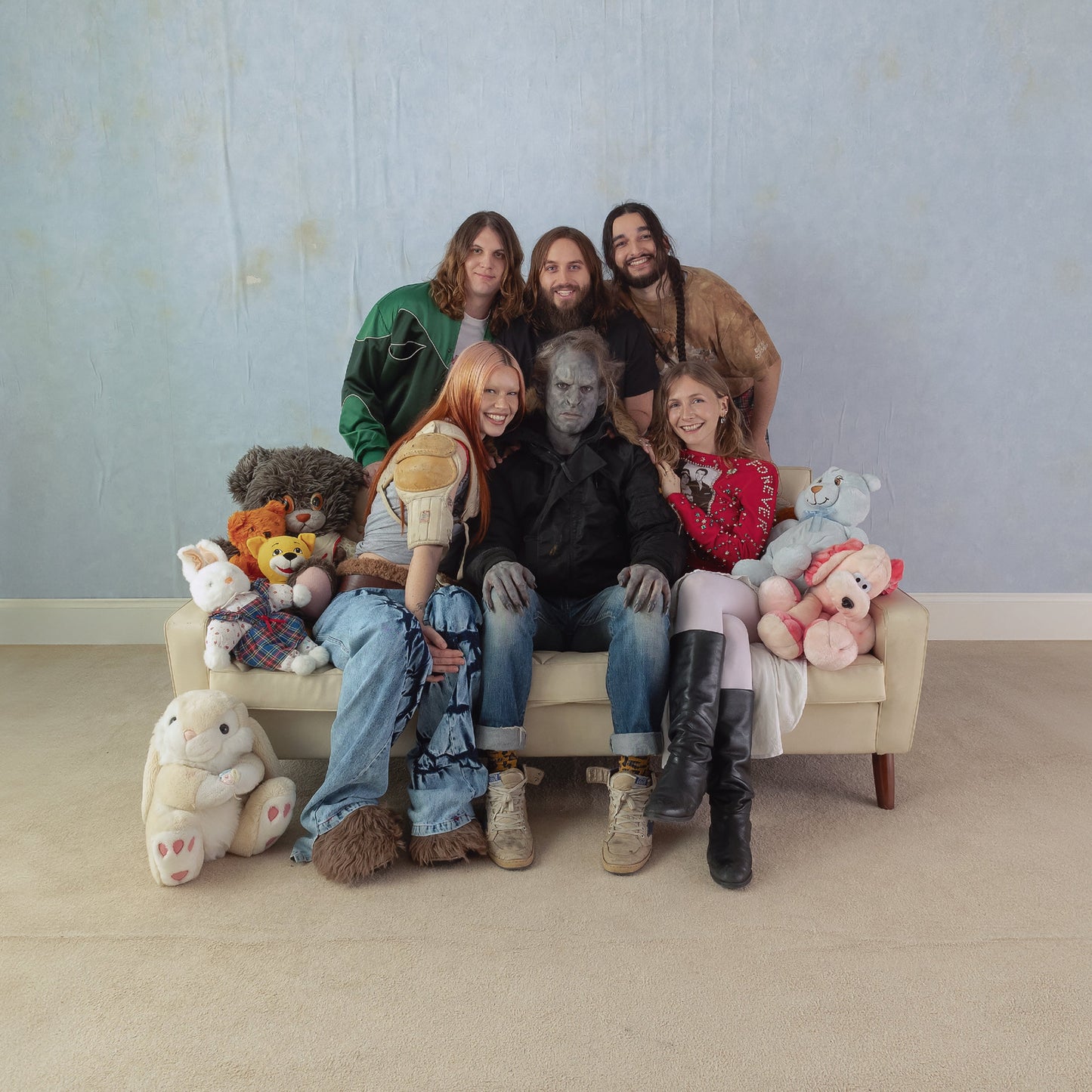 Wet Leg band portrait with costumed figures and plush toys.