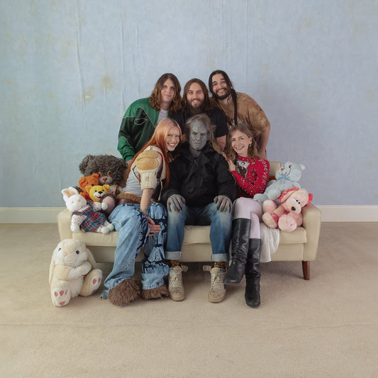 Wet Leg band portrait with costumed figures and plush toys.