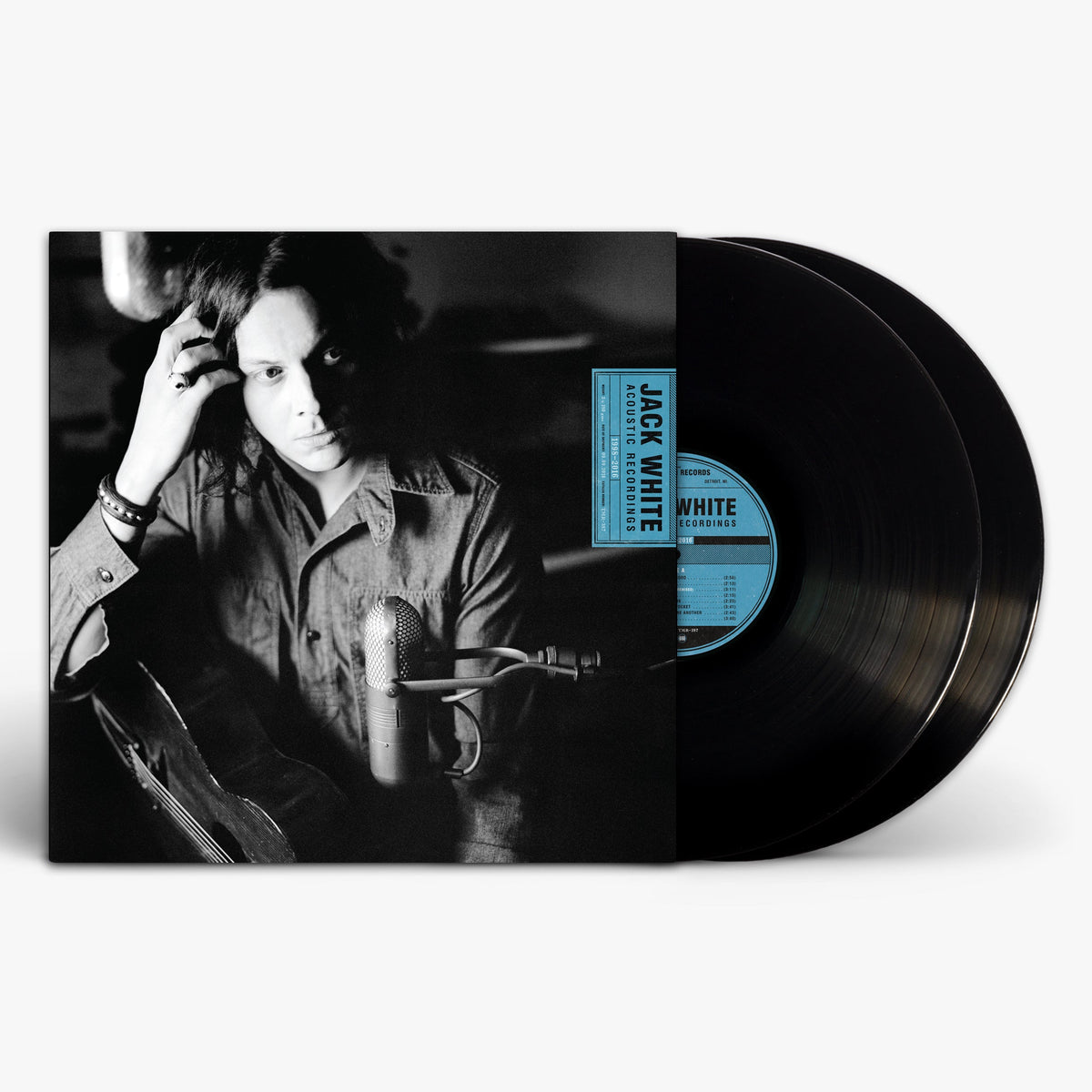 Black and white portrait of Jack White with an acoustic guitar and vintage microphone.