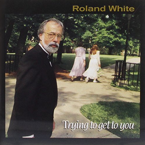 "Album cover with a man in a suit and two women walking in a park."