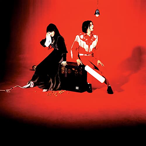 Two figures sit against a red background with a vintage suitcase.